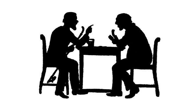 Schattenriss in schwarz vor weißem Hintergrund. Zwei Personen sitzen sich an einem Tisch gegenüber und unterhalten sich.